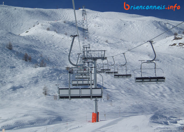 à bord du télésiège, au-dessus des deux pistes rouges